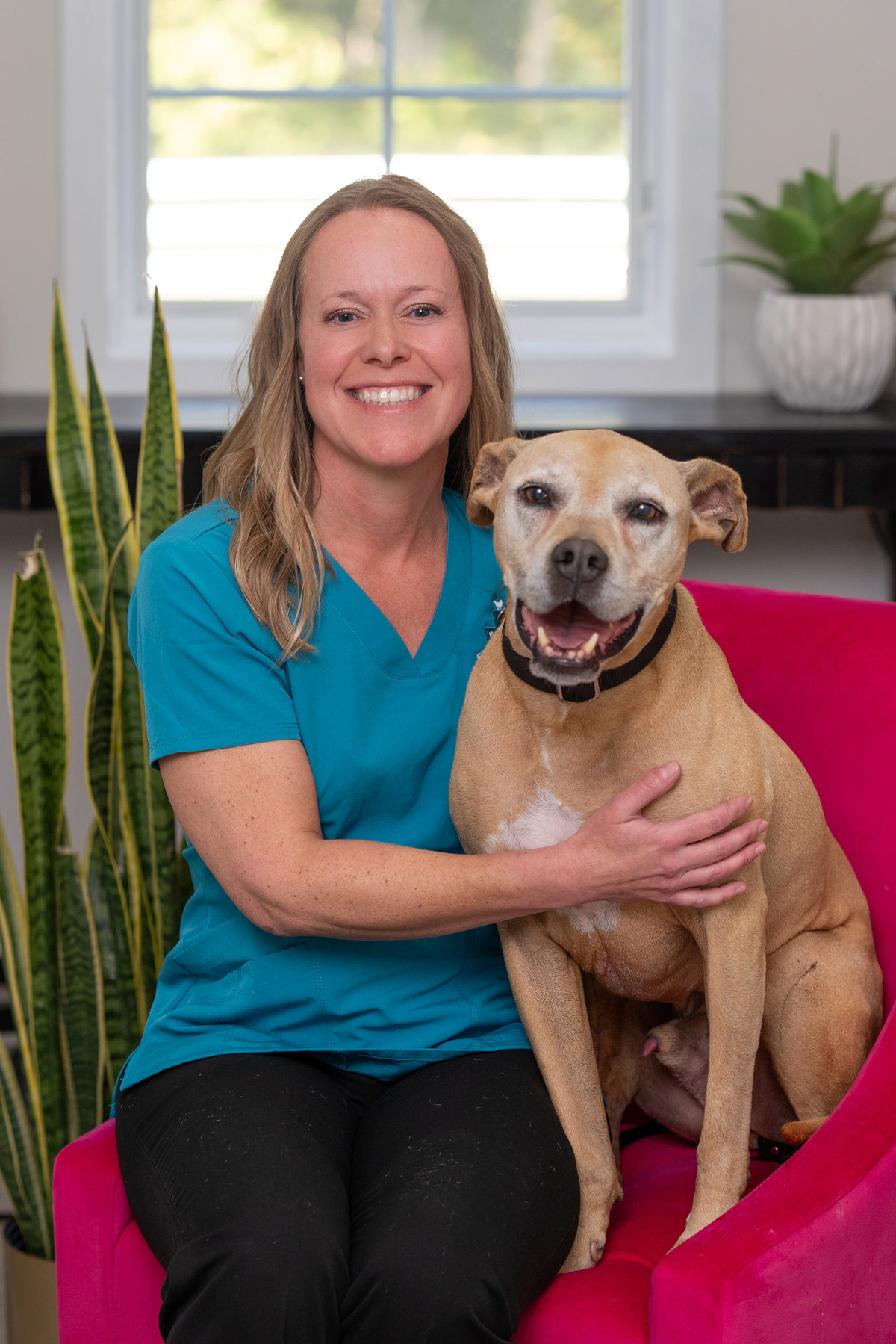 woman smiling sitting next to a dog